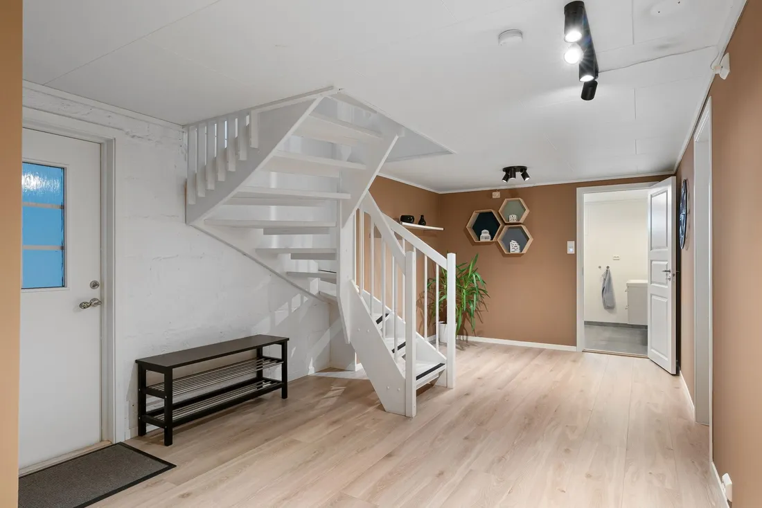 Escalier tournant blanc dans l'entrée d'une maison