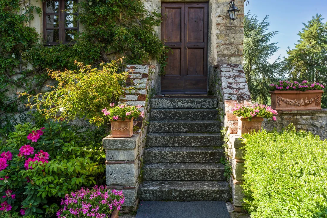 Marches de pierre fleuries menant à la porte d'une maison