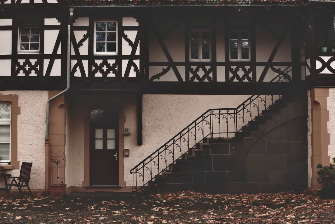 Maison à colombages avec un escalier extérieur à rampe métallique