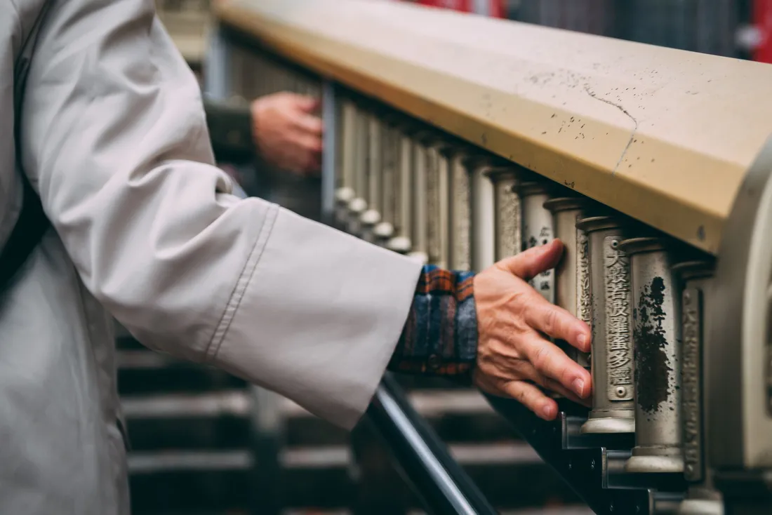 Main posée sur la rampe d'un escalier en pierre